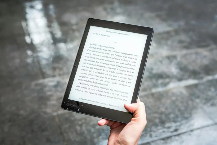 A person holding an e-reader displaying an open document, symbolizing digital document management and reading.